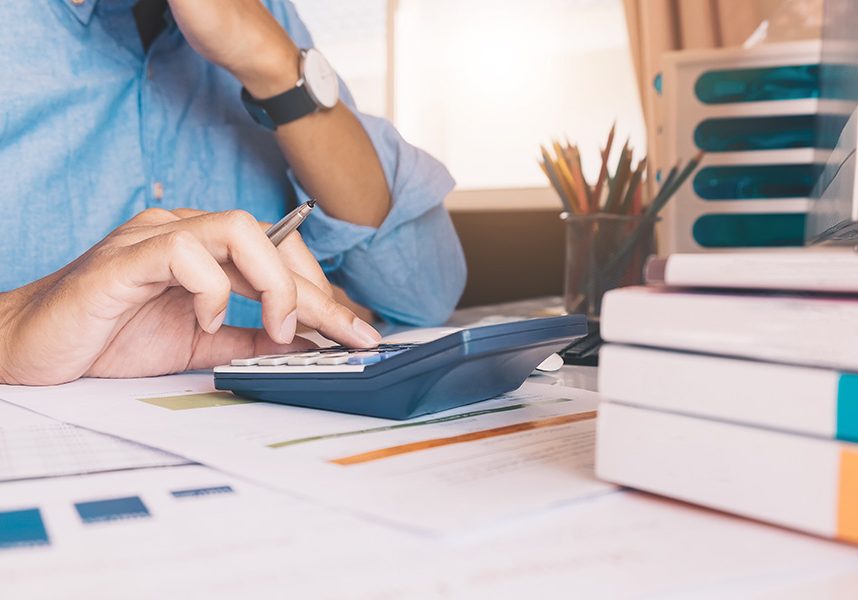 Close up Businessman using calculator and laptop for do math fin Close up Businessman using calculator and laptop for do math finance on wooden desk in office and business working background, tax, accounting, statistics and analytic research concept