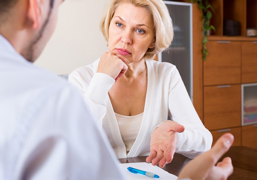 Elderly woman and young man with bills. Mature woman questioning young man about letters from bank at home