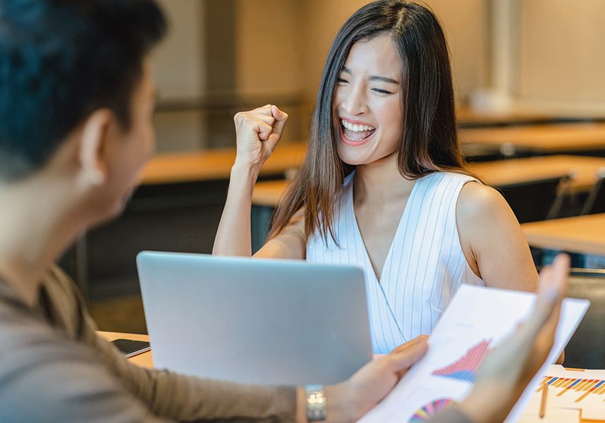 Rear view of Boss congratulating to asian businesswoman in glad Rear view of Boss congratulating to asian businesswoman in glad action when successful project or getting promote, rewarding the business target in modern office, successful business concept