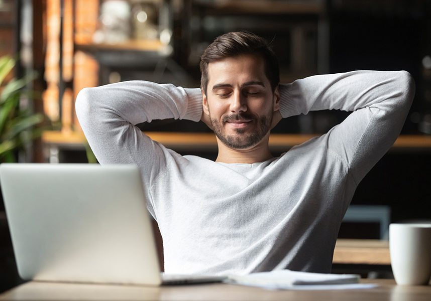 Relaxed happy businessman student worker lounge at desk meditating Relaxed happy businessman student worker lounge at work desk cafe table meditating, positive calm man relax break hold hand behind head dream rest from computer stretch feel no stress peace of mind