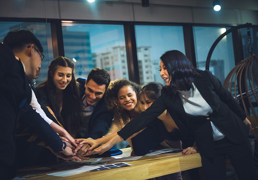 Large business team showing unity with their hands together Large business team showing unity with their hands together